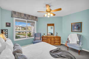 Bedroom with carpet floors, ceiling fan, and baseboards