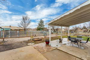 View of patio with outdoor dining area and fence