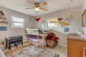 Bedroom with ceiling fan, carpet flooring, and baseboards