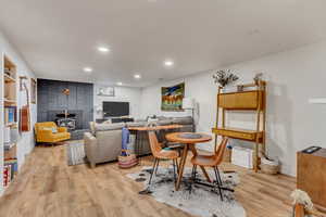 Living room featuring baseboards, recessed lighting, a wood stove, and light wood-style floors