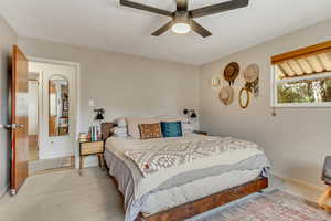 Bedroom with light carpet, baseboards, and a ceiling fan