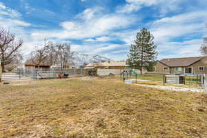 View of yard with an outbuilding, fence, an exterior structure, a mountain view.