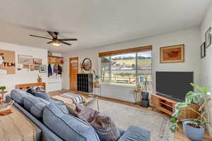 Living room with baseboards, a ceiling fan, and wood finished floors