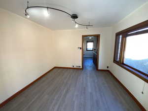 Spare room featuring dark wood-style flooring and track lighting
