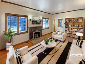 Living area featuring crown molding, baseboards, wood finished floors, and a tile fireplace