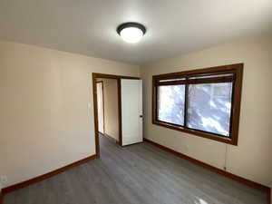 Unfurnished bedroom with wood finished floors and a closet