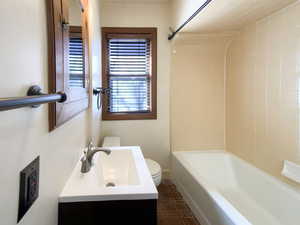 Bathroom with  shower combination, vanity, and toilet