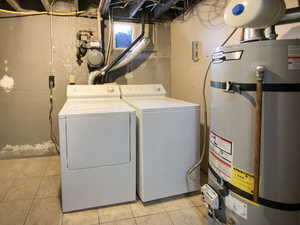 Clothes washing area with laundry area, water heater, independent washer and dryer, and light tile patterned flooring