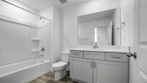 Bathroom featuring shower / tub combination, toilet, wood finished floors, vanity, and visible vents