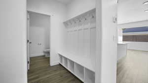 Mudroom with a textured ceiling, baseboards, and wood finished floors