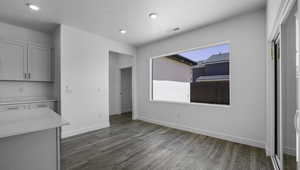 Unfurnished dining area featuring a textured ceiling, recessed lighting, wood finished floors, visible vents, and baseboards