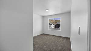 Carpeted empty room with visible vents, baseboards, and a textured ceiling