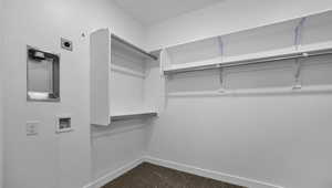 Spacious closet featuring dark carpet