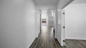 Corridor featuring wood finished floors and baseboards