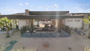 Rear view of property featuring a patio area, fence, and stucco siding