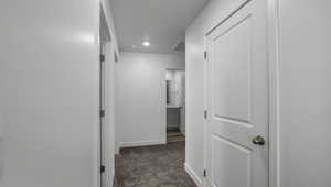 Corridor with carpet floors, visible vents, and baseboards