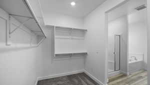 Walk in closet featuring visible vents and wood finished floors