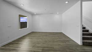 Spare room featuring recessed lighting, stairway, a textured ceiling, wood finished floors, and baseboards