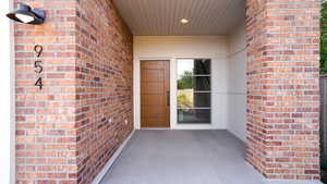 Property entrance featuring brick siding