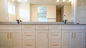 Full bathroom with double vanity, visible vents, and a sink