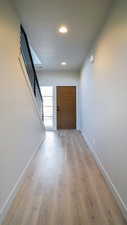 Interior space with light wood-type flooring, stairway, baseboards, and recessed lighting