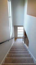 Stairway featuring a high ceiling and baseboards