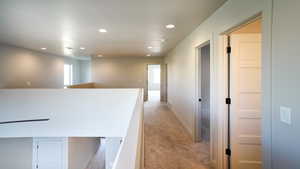 Corridor featuring light carpet, recessed lighting, baseboards, and an upstairs landing