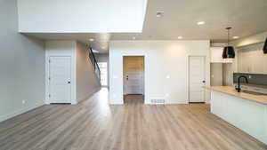 Kitchen featuring light wood finished floors, a sink, visible vents, and recessed lighting