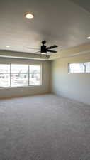 Empty room with a healthy amount of sunlight, carpet, baseboards, and a ceiling fan