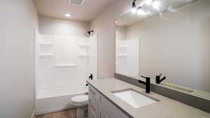 Bathroom with shower / bathtub combination, toilet, wood finished floors, vanity, and visible vents