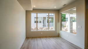 Spare room featuring recessed lighting, light wood-type flooring, visible vents, and baseboards