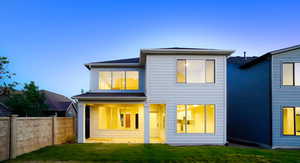 Rear view of property featuring fence and a lawn