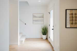 Interior space with stairway, wood finished floors, and baseboards