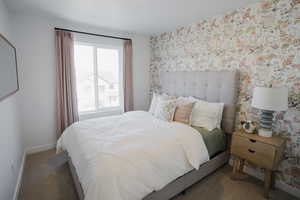 Carpeted bedroom featuring wallpapered walls and baseboards