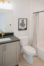 Bathroom with toilet, shower / tub combo, tile patterned flooring, and vanity
