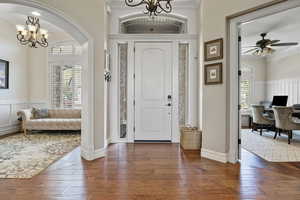 Foyer with ornamental molding, a wealth of natural light, and hardwood / wood-style floors