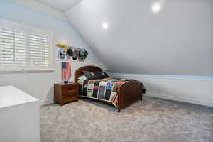Bedroom with lofted ceiling and carpet flooring