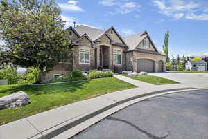 Craftsman inspired home featuring a garage, a shingled roof, concrete driveway, stucco siding, and a front lawn