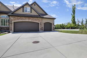View of front of home with driveway, an attached garage, roof with shingles, and stucco siding