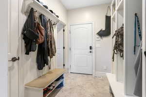 Mudroom with light tile patterned floors, visible vents, and baseboards