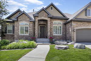 View of front facade with a garage and stucco siding