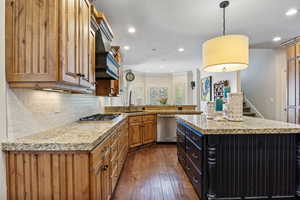 Kitchen featuring recessed lighting, stainless steel appliances, dark wood-style flooring, a sink, and decorative backsplash