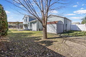 View of yard with an outbuilding, a gate, fence, and central air condition unit