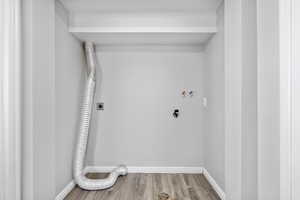 Washroom with washer hookup, wood finished floors, electric dryer hookup, and baseboards