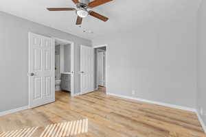 Unfurnished bedroom with ensuite bathroom, ceiling fan, light wood finished floors, and baseboards