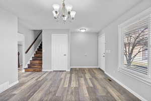 Interior space featuring stairway, wood finished floors, visible vents, and baseboards