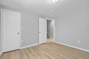 Unfurnished bedroom featuring light wood-style floors, visible vents, and baseboards