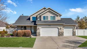 View of front of house featuring stucco siding, fence, a front yard, and a gate