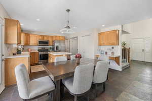 Dining space featuring stone tile floors, stairway, recessed lighting, and baseboards