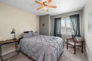 Carpeted bedroom with baseboards and ceiling fan